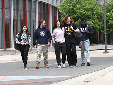 Five students walking on a pathway on the 91 campus.